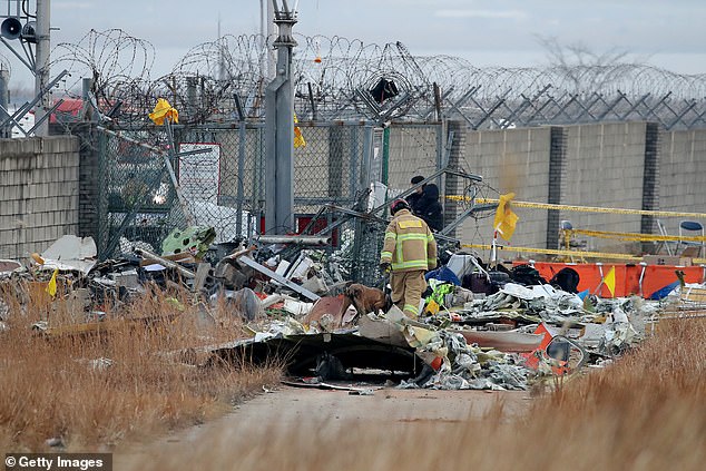 Firefighters work at the wreckage site of the Jeju Air plane in Muan on December 30