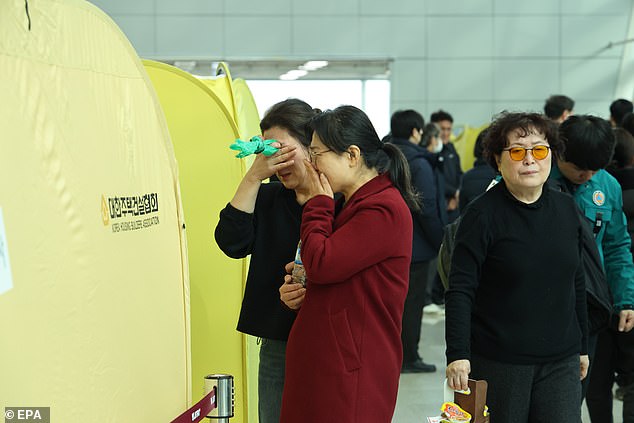 Family members of a victim of the Jeju Air plane crash grieve at a temporary shelter at Muan International Airport