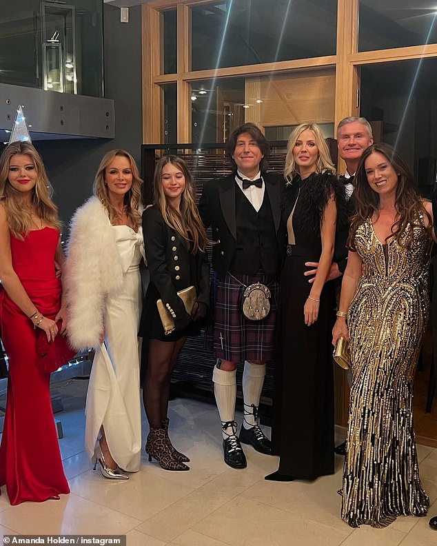 Amanda made sure all eyes were on her in a stunning white satin gown as she posed with her husband Chris Hughes and her lookalike daughters Lexi, 18, and Hollie, 13, and former Formula One driver David Coulthard