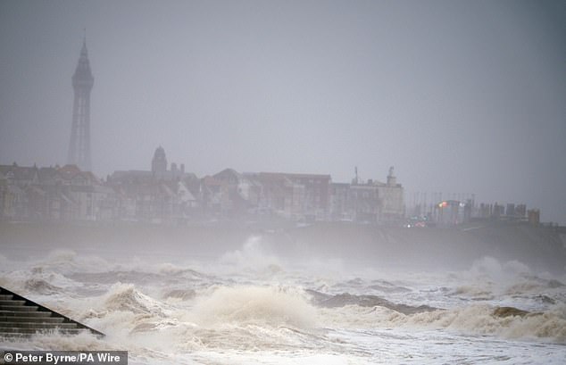 Waves strike Cleveleys Beach near Blackpool in Lancashire today amid the stormy weather