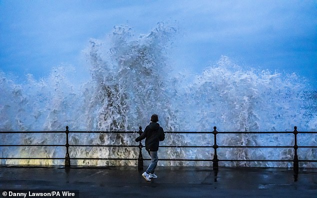 People watch waves crashing in Scarborough, North Yorkshire, as snow, rain and wind warnings are in force and are expected to cause travel issues on New Year's Eve. Picture date: Tuesday December 31, 2024