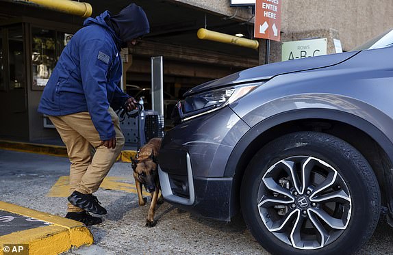 Security and bomb sniffing dogs check vehicles as they enter the Superdome parking garage ahead of the Sugar Bowl NCAA College Football Playoff game, Thursday, Jan. 2, 2025, in New Orleans. (AP Photo/Butch Dill)