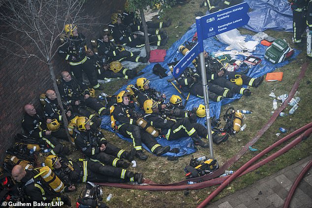 Research from the Journal of Occupational and Environmental Medicine revealed that of the 524 firefighters who attended the tragedy, more than a quarter reported life-changing conditions. Pictured: A large group of firefighters rest at the scene of a huge fire at Grenfell tower block