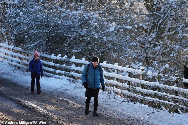 People walk through snow in Balerno, Edinburgh,yesterday as the wintry weather continues