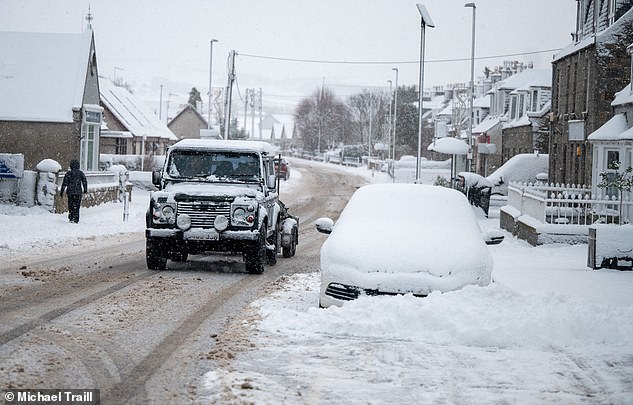 Heavy snow falls across Aberdeenshire on Friday as vehicles are driven through Alford