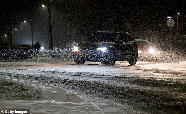 Vehicles negotiating the snow in dangerous conditions