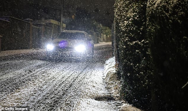 A car navigates his way down a hill through snow