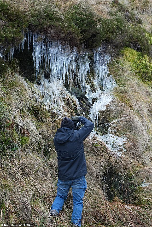 A man takes pictures of icicles at the Wicklow Gap mountain pass in Co Wicklow as Ireland enters a cold snap