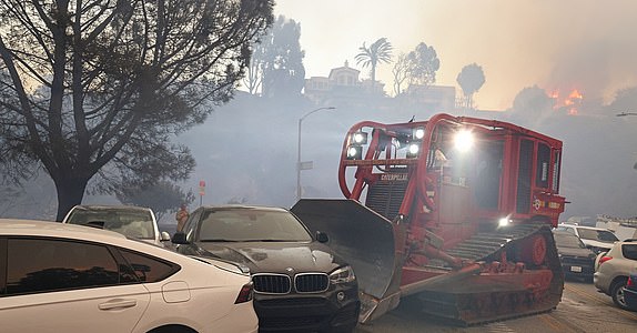 Mandatory Credit: Photo by Jonathan Alcorn/ZUMA Press Wire/Shutterstock (15083449d) A fire department bulldozer moves abandoned cars which blocked Sunset Blvd. California Wildfires 2025: Pacific Palisades, Los Angeles, USA - 07 Jan 2025