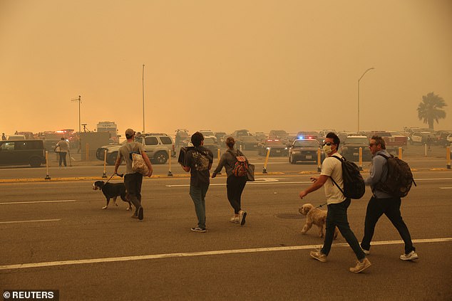 People evacuate as a wildfire breaks-out near Pacific Palisades on the west side of Los Angeles