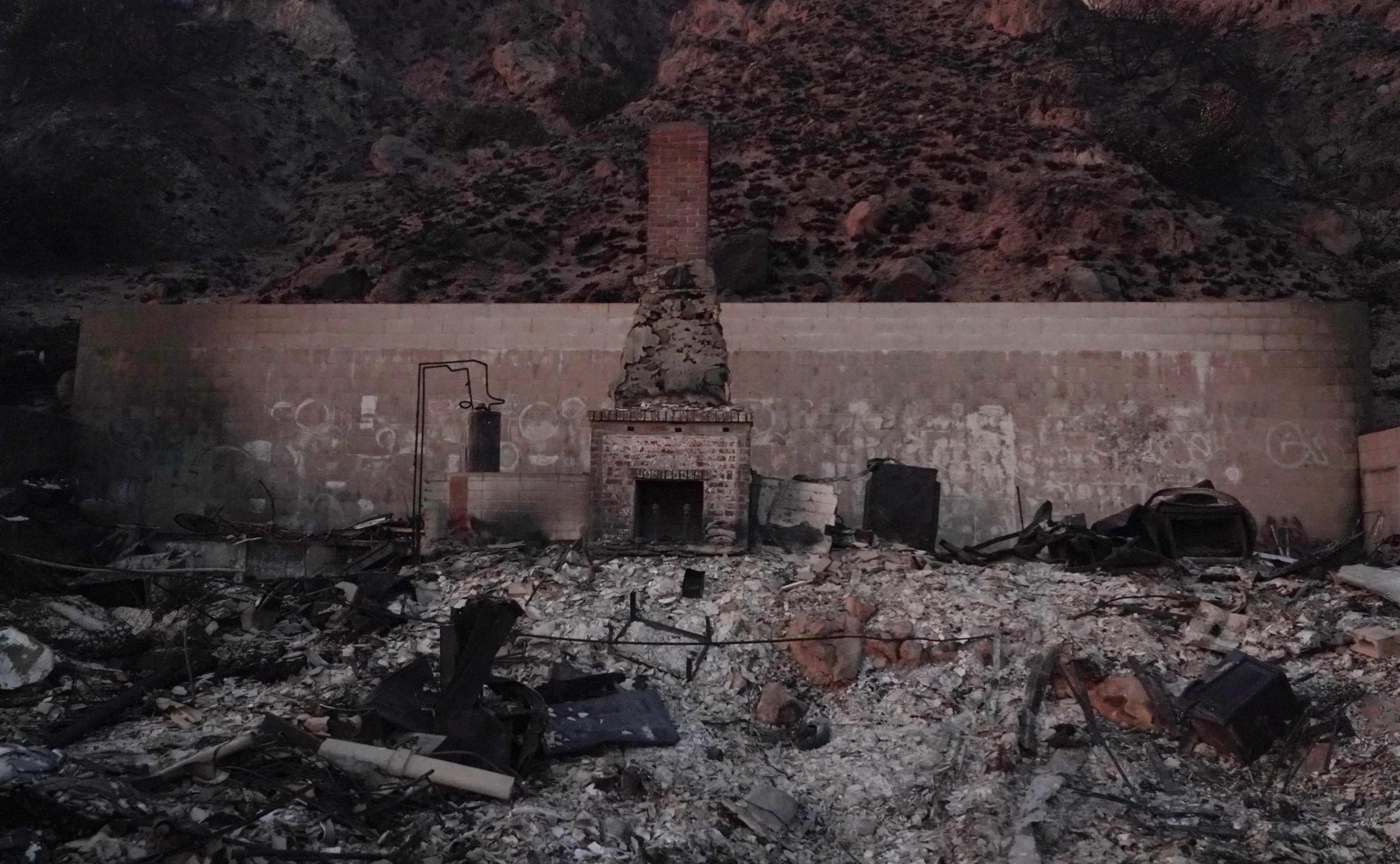 A chimney stands against the back wall of a house reduced to ashes in the Palisades Fire,along the Pacific Coast Highway in Malibu, California, January 9, 2025. (AFP)