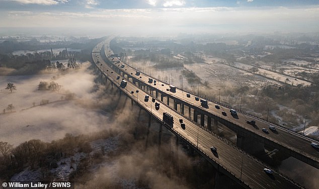 WARRINGTON: Snow and fog surrounds Thelwall Viaduct in Lymm, Warrington, England, as it carries the M6 motorway across the Manchester Ship Canal and the River Mersey