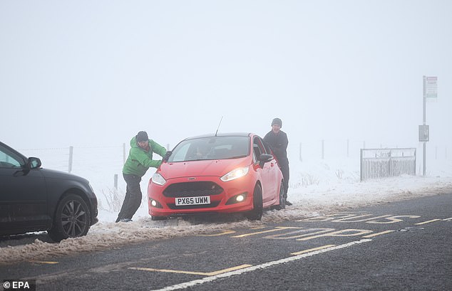 DERBYSHIRE: Members of Mountain Rescue help a motorist amidst white-out conditions on Snake Pass on Thursday