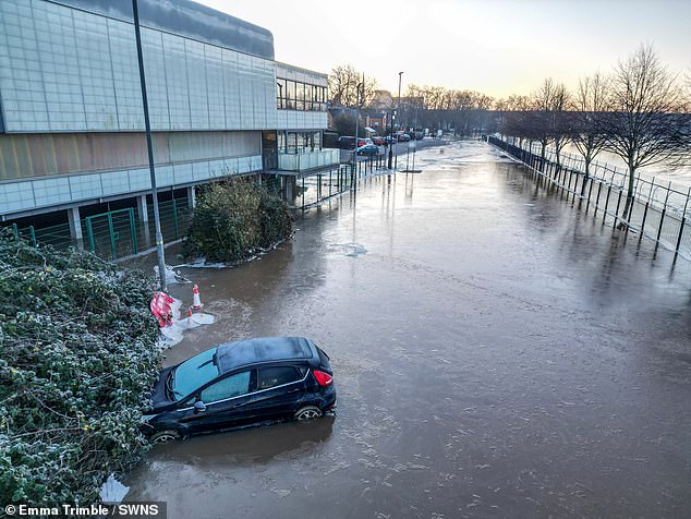 A car lies submerged in frozen floodwater at Pitchcroft Racecourse on Thursday morning