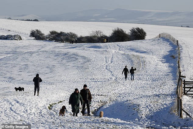 DITCHLING: Walkers enjoy the snow at Ditchling Beacon on Thursday morning