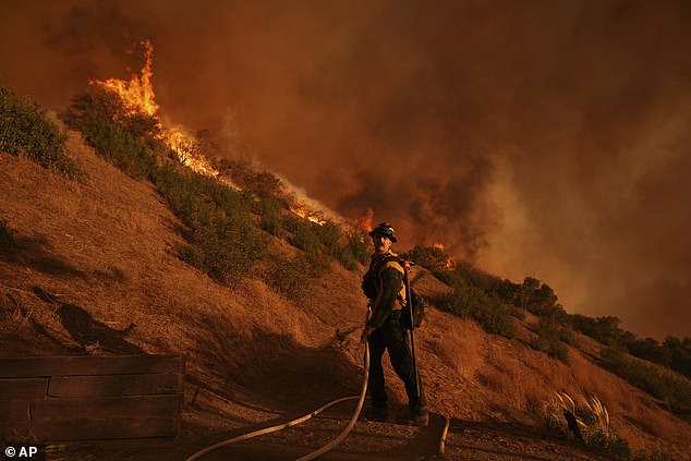 A firefighter battles the Palisades Fire in Mandeville Canyon today