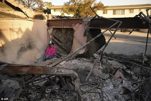 A woman sits as she sifts through the rubble of her mother's home after it was destroyed by the Palisades Fire