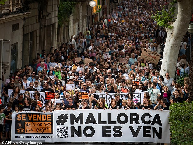 Protesters hold a banner reading "Mallorca is not for sale" at an anti-mass tourism protest on May 25, 2024