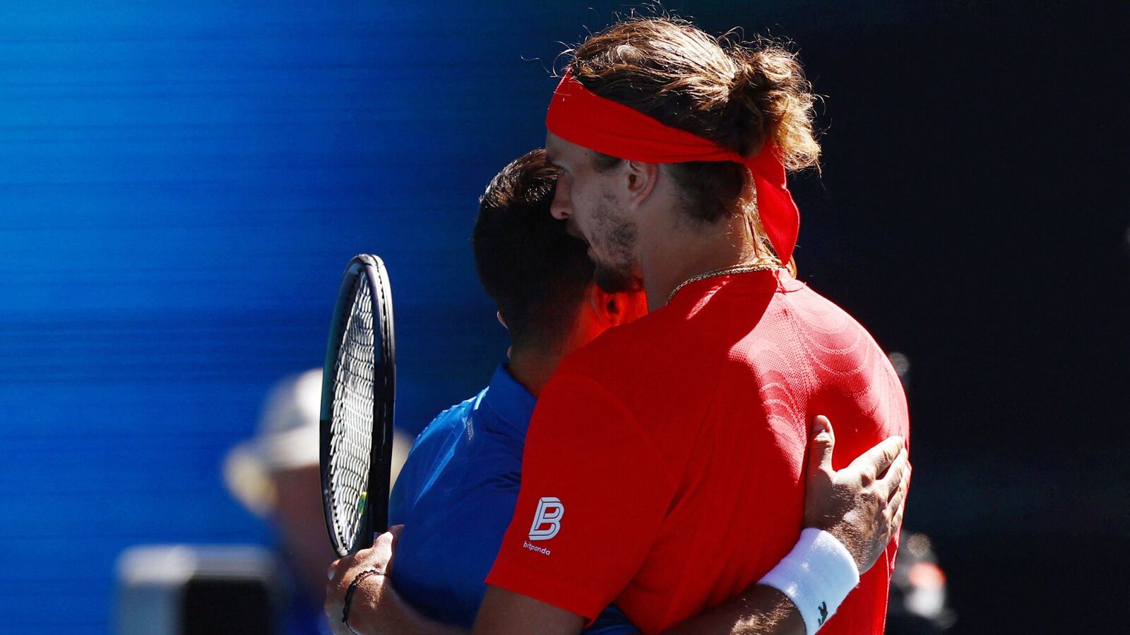 Serbia's Novak Djokovic hugs Germany's Alexander Zverev after retiring from their semi final match of Australian Open 2025 at Melbourne Park on 24 January. (REUTERS/Edgar Su)