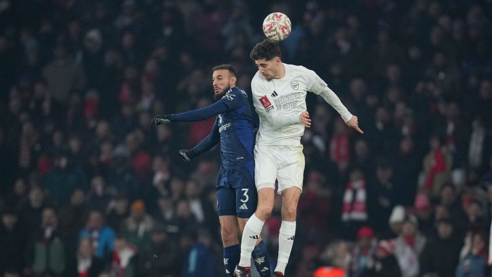 FA Cup 2025: Arsenal's Kai Havertz, right, jumps for the ball with Manchester United's Noussair Mazraoui during a soccer match between Arsenal and Manchester United at the Emirates stadium in London, Sunday, Jan. 12, 2025. (AP Photo/Kin Cheung)