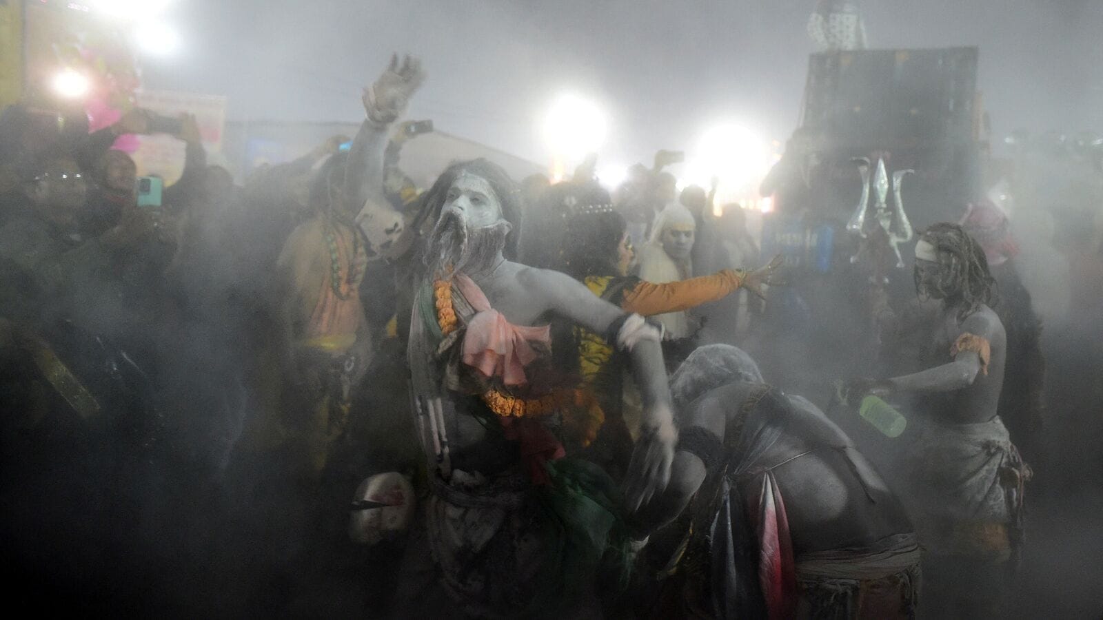 Naga Sadhus or Hindu holy men from Niranjani Akhara and devotees cross a pontoon bridge spanning the river Ganga as they take part in a religious procession during 'Peshwai' or the arrival of the members of an akhara or sect of sadhus for the upcoming 'Maha Kumbh Mela' in Prayagraj, India, January 4, 2025. 