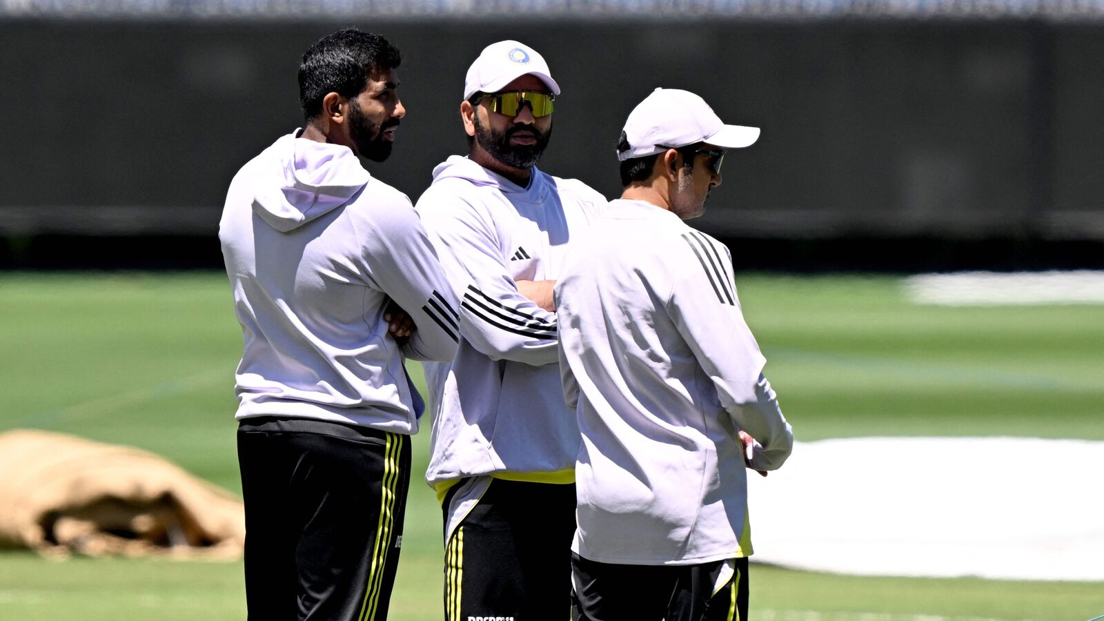 Indian bowler Jasprit Bumrah (L), captain Rohit Sharma (C) and coach Gautam Gambhir (R) inspect the match wicket at the Melbourne Cricket Ground (MCG) in Melbourne on December 24, 2024, ahead of the fourth cricket Test match between Australia and India starting December 26. (Photo by William WEST / AFP)