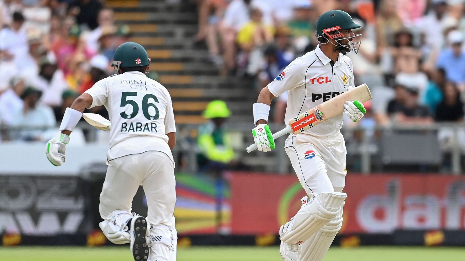 Pakistan's Babar Azam (L) and Pakistan's Shan Masood run between the wickets during the third day of the second international Test cricket match between South Africa and Pakistan at Newlands stadium in Cape Town on January 5, 2025. (Photo by Rodger Bosch / AFP)