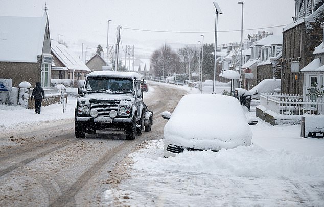 Heavy snow falls across Aberdeenshire today as vehicles are driven through Alford