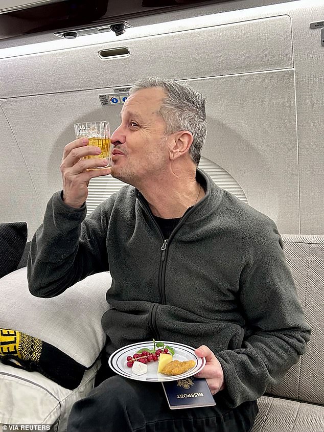 Fogel kisses a drink on an airplane flying him back to the United States after U.S. Special Envoy Steve Witkoff secured his release February 11, 2025