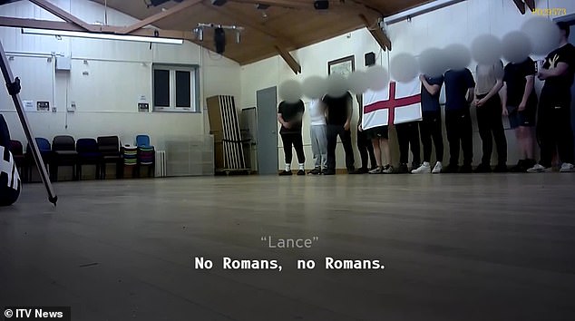 The group poses with an England flag inside a gym during a training session