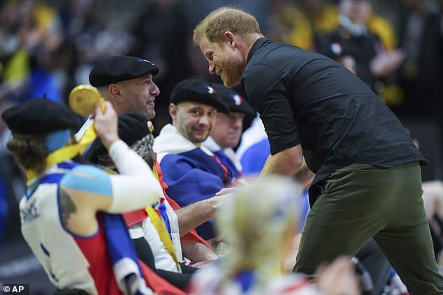 Harry hands out gold medals to French athletes after they defeated the UK yesterday