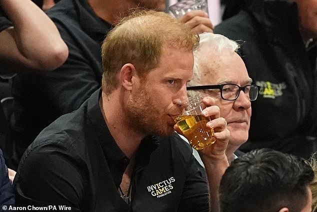 Harry sipped from a glass of local beer as he watched the wheelchair basketball yesterday