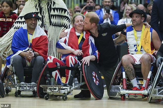 Prince Harry kisses silver medallist Amanda Pye of the UK after the wheelchair rugby final