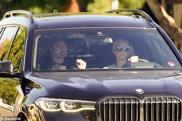 The duo cut stern expressions as they drove around