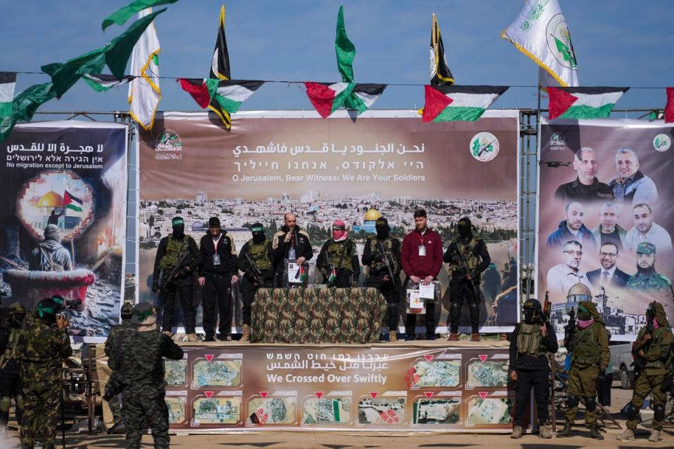 Three hostages held in Gaza, from left, American-Israeli Sagui Dekel Chen, Argentinian-Israeli Iair Horn and Russian-Israeli Alexander (Sasha) Troufanov, are escorted by Hamas and Islamic Jihad fighters (AP)