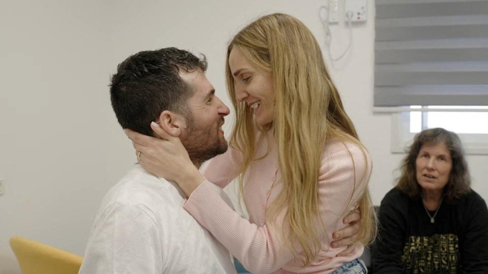 Dekel-Chen embraces his wife Avital as he is reunited with his family in Israel (via REUTERS)