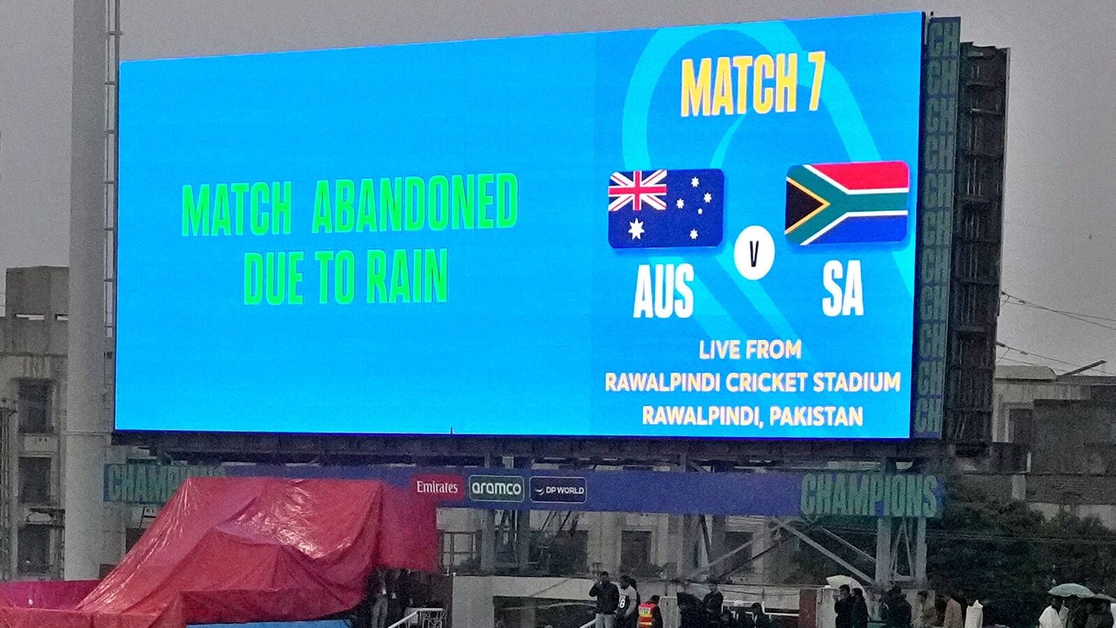 Fans look big screen showing massaging the ICC Champions Trophy 2025 match between Australia and South Africa is abandoned due rain, in Rawalpindi.