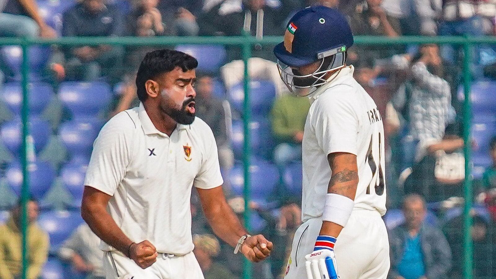 Railways' Himanshu Sangwan celebrates the wicket of Delhi's Virat Kohli during their Ranji Trophy encounter in New Delhi.