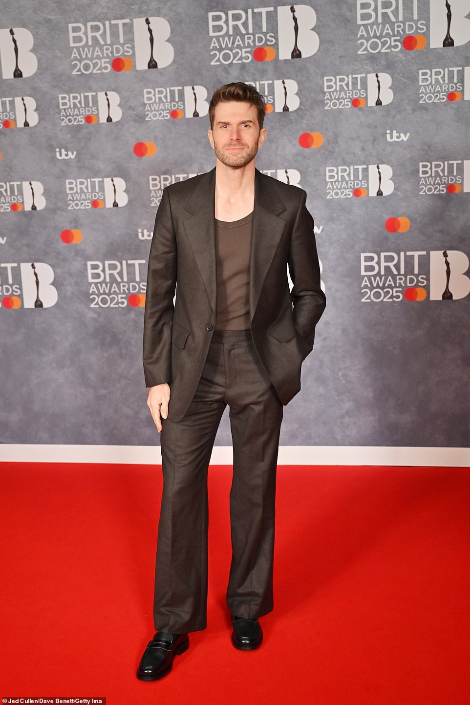 Joel Dommett cut a suave figure in a brown suit and a matching vest top, which he paired with smart black loafers