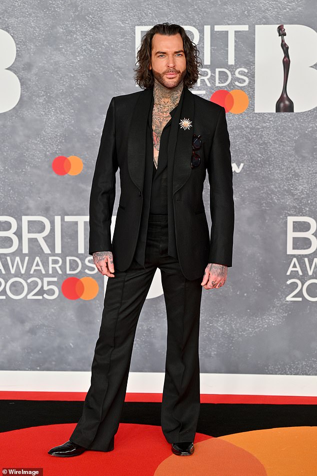 Pete looked typically dapper in a fitted black suit and a matching collared shirt, left half unbuttoned to show off his tattoos.