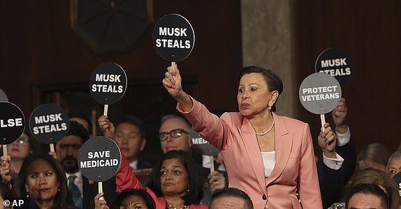 Rep. Nydia Velazquez, D-N.Y., holds a protest sign with fellow Democrats as President Donald Trump addresses a joint session of Congress at the Capitol in Washington, Tuesday, March 4, 2025. (Win McNamee/Pool Photo via AP)