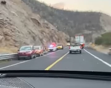 Five of the nine missing students' remains were found underneath a blood-soaked tarp, while the remaining four were found inside the trunk. Pictured: Onlookers capture the scene unfolding along the side of the high-trafficked Cuacnopalan-Oaxaca highway