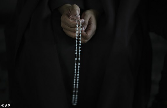 A man holds a rosary beads during a rosary prayer for Pope Francis' health in St. Peter's Square at the Vatican, Tuesday, March 4, 2025. (AP Photo/Alessandra Tarantino)