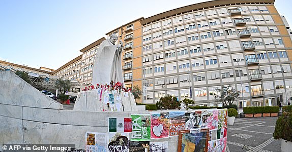 Posters and messages for Pope Francis are pasted near the statue of John Paul II outside the Gemelli University Hospital where Pope Francis is hospitalized with pneumonia, in Rome on March 6, 2025. (Photo by Andreas SOLARO / AFP) (Photo by ANDREAS SOLARO/AFP via Getty Images)