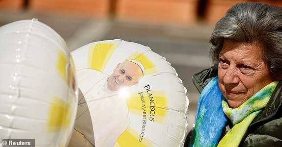 Carmela Vittoria Mancuso, 79, sits near balloons with an image of Pope Francis outside Gemelli Hospital, where Pope Francis continues his treatment, in Rome, Italy, March 4, 2025. REUTERS/Yara Nardi