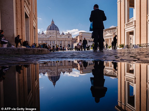 St Peter's basilica reflects in a puddle in The Vatican on March 04, 2025. Pope Francis was breathing without a mask on March 4, 2025 after suffering two bouts of acute respiratory failure, the Vatican said as the leader of the world's Catholics spent his 19th day in hospital with pneumonia. (Photo by Dimitar DILKOFF / AFP) (Photo by DIMITAR DILKOFF/AFP via Getty Images)