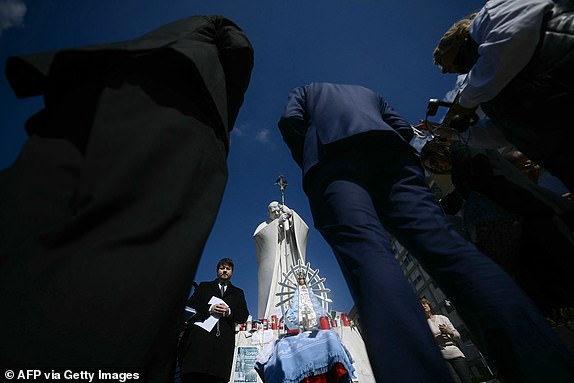 Faithful from Argentina gather to pray with a statue of Our Lady of Lujan, near the statue of John Paul II outside the Gemelli University Hospital where Pope Francis is hospitalized with pneumonia, in Rome on March 04, 2025. Pope Francis "slept all night long" the Vatican said on March 4, 2025 after he suffered two breathing attacks on Monday, as the 88-year-old pontiff struggles to recover from pneumonia. (Photo by Filippo MONTEFORTE / AFP) (Photo by FILIPPO MONTEFORTE/AFP via Getty Images)