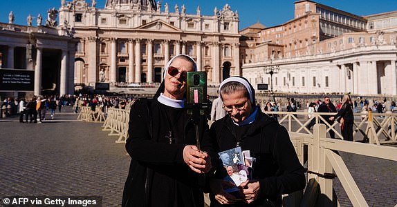 TOPSHOT - A nun holds a selfie stick at St Peter's square in The Vatican, on March 4, 2025. Pope Francis was breathing without a mask on March 4, 2025 after suffering two bouts of acute respiratory failure, the Vatican said as the leader of the world's Catholics spent his 19th day in hospital with pneumonia. (Photo by Dimitar DILKOFF / AFP) (Photo by DIMITAR DILKOFF/AFP via Getty Images)