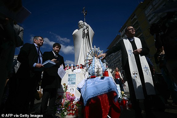 Faithful from Argentina gather to pray with a statue of Our Lady of Lujan in front of the statue of John Paul II outside the Gemelli University Hospital where Pope Francis is hospitalized with pneumonia, in Rome on March 04, 2025. Pope Francis "slept all night long" the Vatican said on March 4, 2025 after he suffered two breathing attacks on Monday, as the 88-year-old pontiff struggles to recover from pneumonia. (Photo by Filippo MONTEFORTE / AFP) (Photo by FILIPPO MONTEFORTE/AFP via Getty Images)