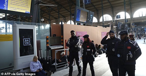 SNCF employees walk past an information screen displaying that traffic has been stopped at the Gare du Nord station in Paris on March 7, 2025, following the discovery of a World War II bomb. Railway services at the Gare du Nord station, that have been interrupted on March 7, 2025 morning after the discovery of a World War II bomb, will remain "highly disrupted throughout the day", warned the Minister for Transport. (Photo by GEOFFROY VAN DER HASSELT / AFP) (Photo by GEOFFROY VAN DER HASSELT/AFP via Getty Images)